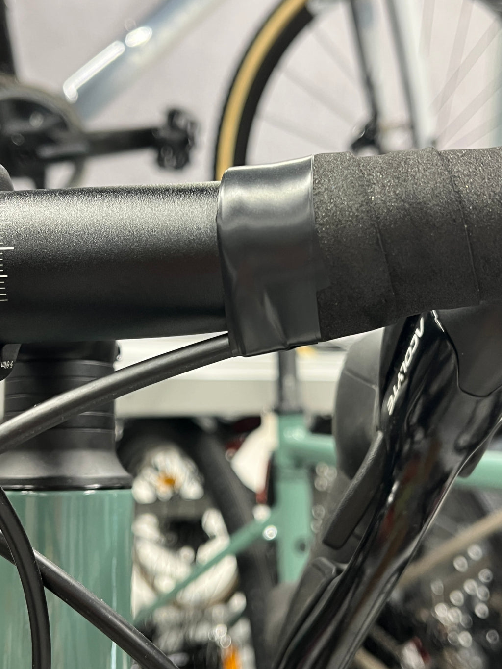 Wrinkled electrical tape finishing the bar tape on a brand new road bike