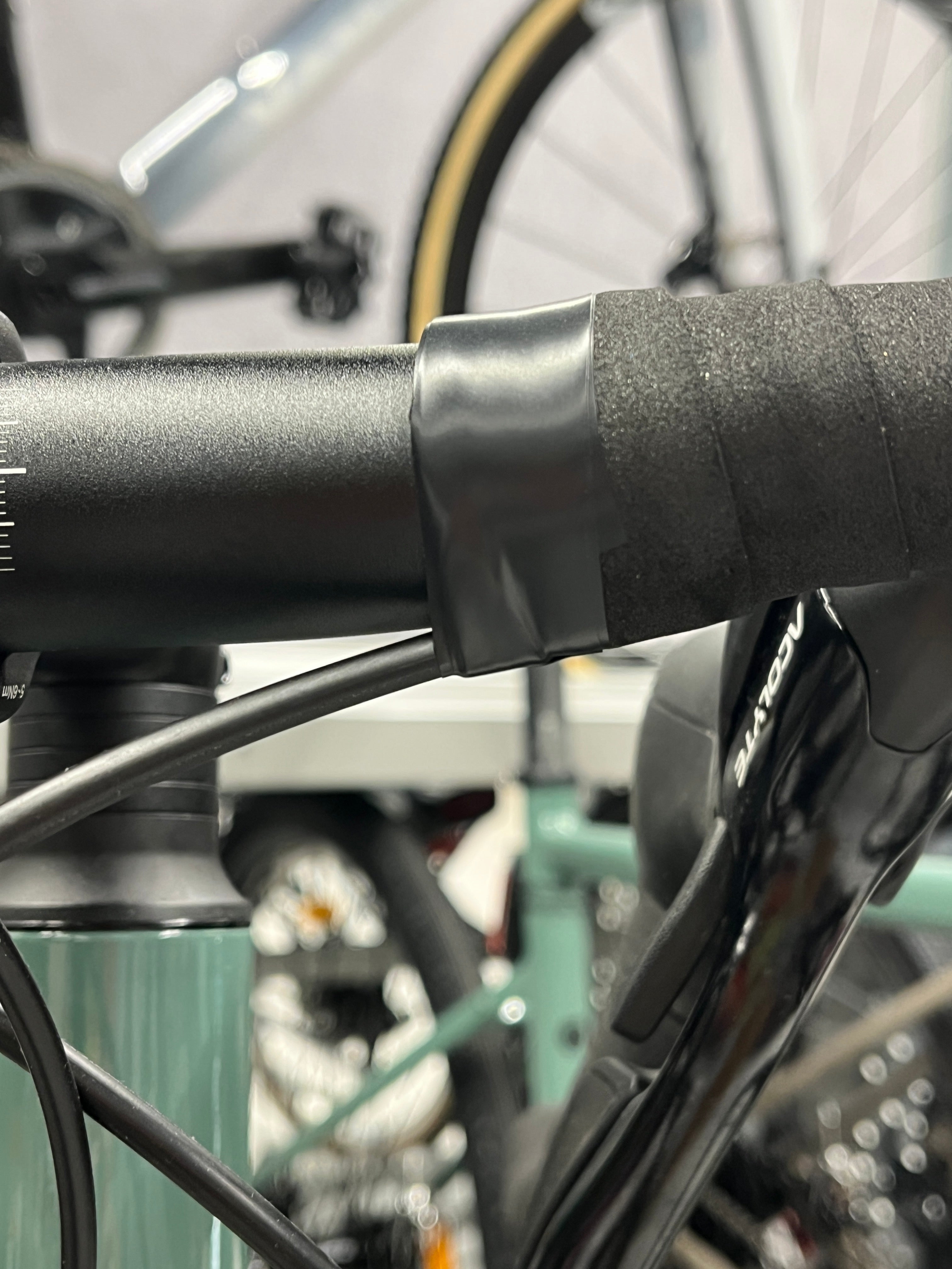 Wrinkled electrical tape finishing the bar tape on a brand new road bike
